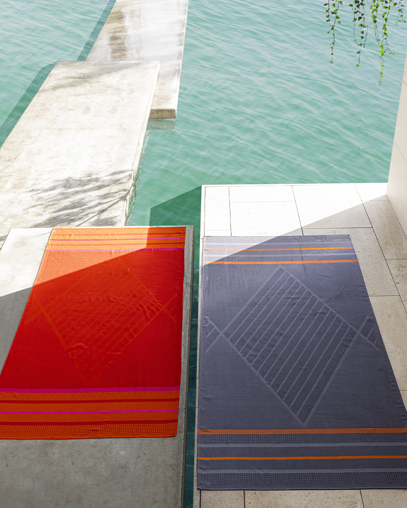 Red and navy beach towels by the water