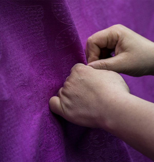 Hands on a purple fabric